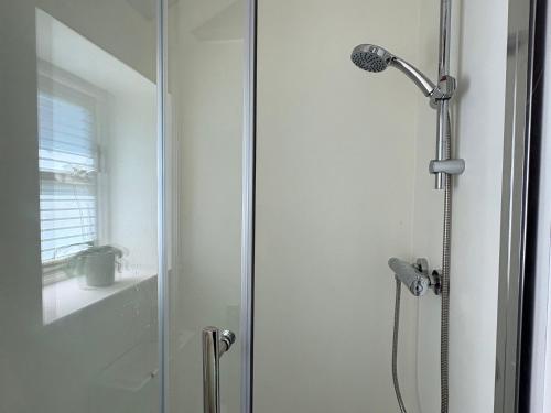 a shower with a glass door in a bathroom at The Old Dairy in Warminster
