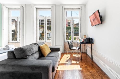a living room with a couch and a table and windows at GuestReady - Porto Home GuestHouse in Porto