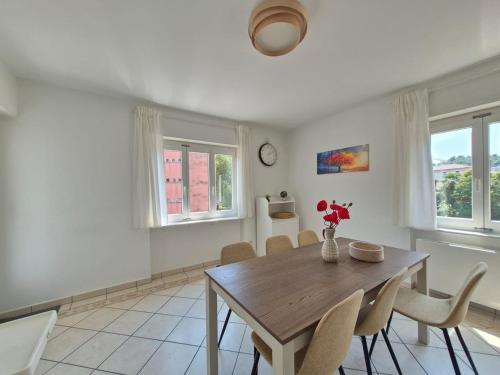 a dining room with a wooden table and chairs at Sunlit Lugano & Parking Free in Massagno
