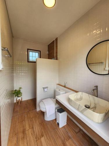a bathroom with a tub and a toilet and a sink at Banrao Pool Villa Khaoyai บ้านเราพูลวิลล่าเขาใหญ่ in Ban Tha Maprang