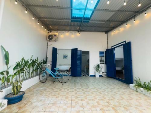 a bike parked in a room with blue doors at Mộc House in Dong Hoi