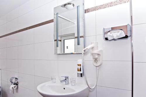 
a bathroom with a sink, mirror, and toilet at Arena Villa am Wasserpark in Frankfurt/Main
