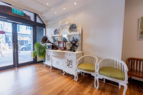 a room with a white dresser and two chairs at iNN at Temple St by Q Loft Newly Renovated in Singapore