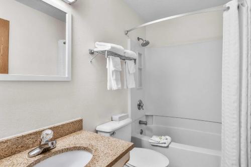 a bathroom with a sink and a toilet and a mirror at Super 8 by Wyndham East Stroudsburg - Poconos in East Stroudsburg