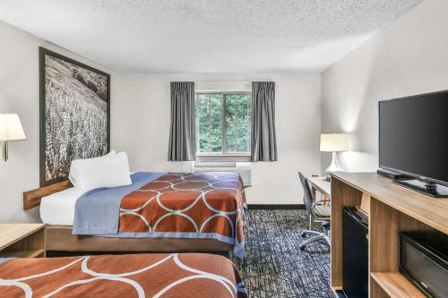 a hotel room with a bed and a flat screen tv at Super 8 by Wyndham East Stroudsburg - Poconos in East Stroudsburg