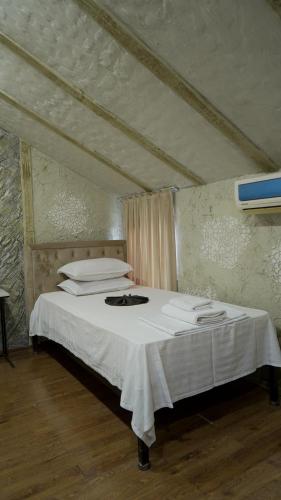 a bedroom with a bed with white sheets and pillows at KHAN Hotel in Kokand