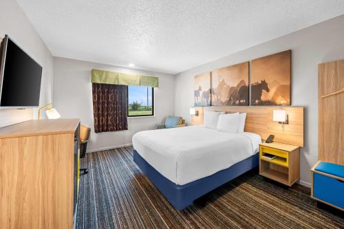 a hotel room with a bed and a flat screen tv at Days Inn by Wyndham York in York