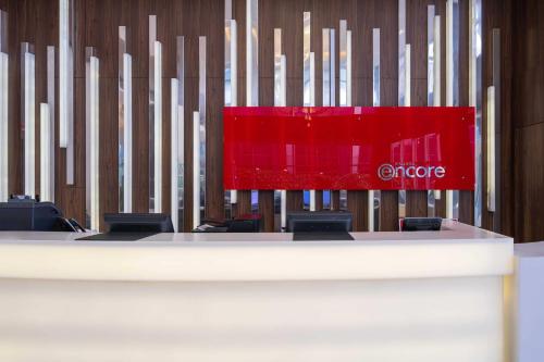 a stage with chairs and a red sign on a wall at Ramada Encore Istanbul Bayrampasa in Istanbul