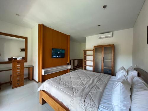 a bedroom with a bed and a sink and a mirror at Balcony Living Apartment in Seminyak