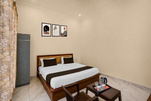 a bedroom with a bed and a table with a chair at Collection O Salasar Balaji Temple Formerly Hanuwant Palace in Sīkar