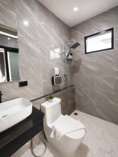 a bathroom with a white toilet and a sink at The Phuview Pool Villa Aonang in Ban Chong Phli