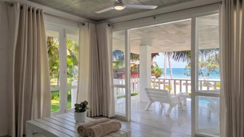 a living room with sliding glass doors with a view of the ocean at Samadhi by the Venus Project in Ranna