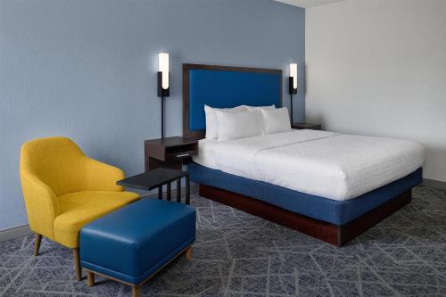 a hotel room with a bed and a chair at Hampton Inn Lawrence in Lawrence