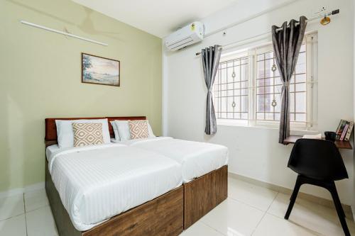 a bedroom with a bed and a desk and windows at Wandr Hotel Brookefield, Bangalore in Bangalore