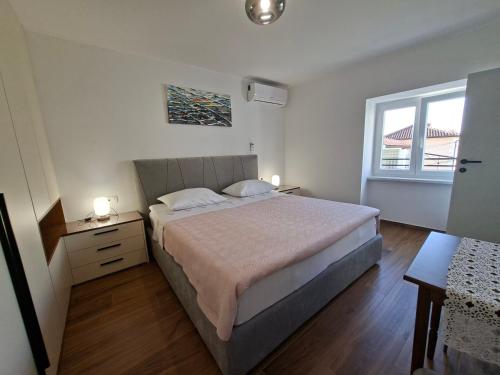a bedroom with a large bed and a window at Vacation home, Ferienhaus KLAUDIA in Kraj, Mošćenička Draga near Opatija in Mošćenička Draga
