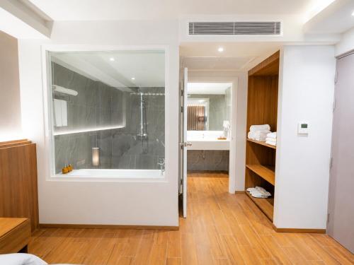 a bathroom with a shower and a bath tub at Shambhala Hotel Pattaya in Pattaya