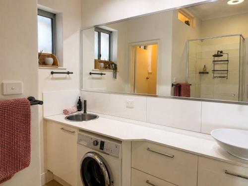 a bathroom with a sink and a washing machine at Ocean Eye in Perth