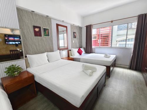a hotel room with two beds and a window at AILEN BOUTIQUE HOTEL in Ho Chi Minh City