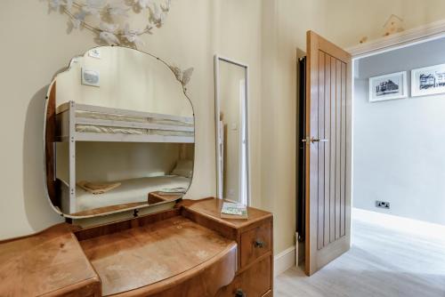 a room with a bunk bed with a mirror at Ocean view in Swanage