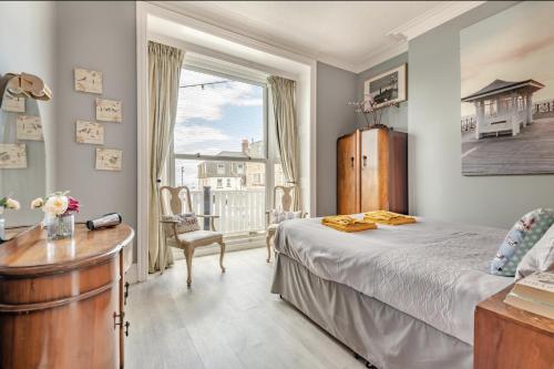 a bedroom with a bed and a desk and a window at Ocean view in Swanage