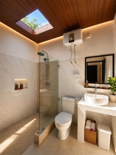 a bathroom with a toilet and a sink and a shower at Penida Cabins in Nusa Penida