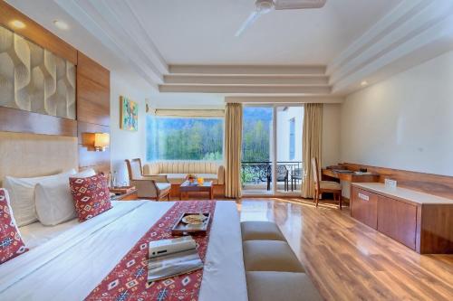 a living room with a large bed and a table at The Allure Grand - Riverside Resort & Spa in Manāli