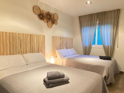a bedroom with two beds with towels on them at Can Vinyals Holiday Home in Castellar