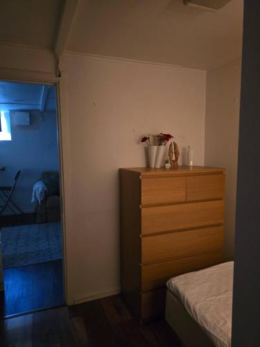 a bedroom with a dresser and a bedroom with a bed at Small cozy basement apartment in Sundsvall