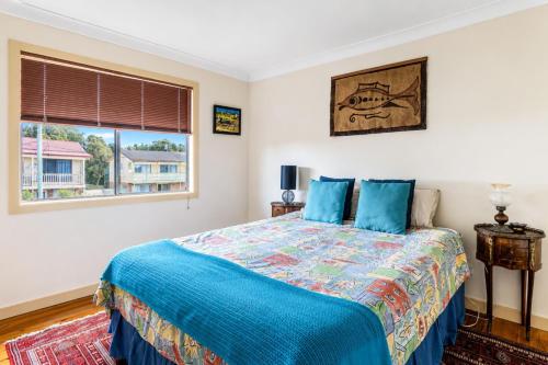 a bedroom with a bed and a window at Waterfront Delight on Cater in Sussex Inlet