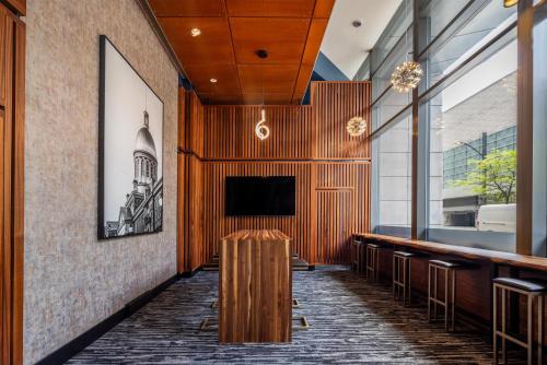 a lobby with a bar with a tv on the wall at Embassy Suites by Hilton - Montreal in Montreal