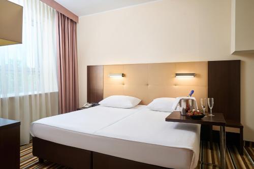 a hotel room with a large bed and a window at Hotel Victor Pruszków DeSilva in Pruszków