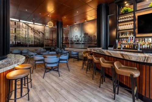 a restaurant with a bar with stools at Embassy Suites by Hilton - Montreal in Montreal