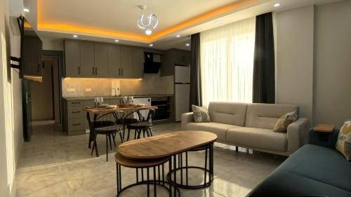 a kitchen and living room with a couch and a table at Hillfort Suites Apart Otel in Demre