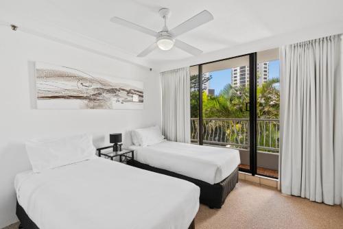 a hotel room with two beds and a balcony at Aegean Apartments Surfers Paradise in Gold Coast