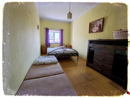 a room with a bedroom with a bed and a dresser at Chalupa nad Dvorem in Slezské Pavlovice