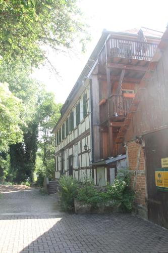 a building with a balcony on the side of it at Ferienwohnung Mühlradblick in Geismar