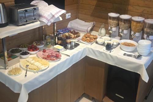 Una mesa con muchos tipos diferentes de comida sobre ella. en Transylvania Villa & Spa, en Muntele Băişorii