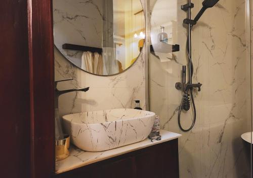 a bathroom with a sink and a shower with a mirror at Geza Breeze Residence in Kigamboni