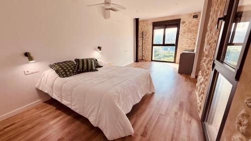 a bedroom with a bed with a white comforter at Casa Lia in Alcocer de Planes
