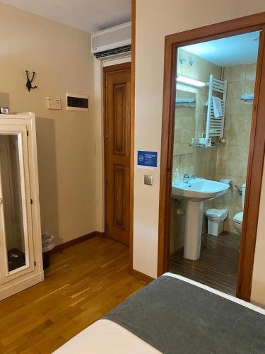 a bathroom with a sink and a toilet and a mirror at Alda A Boira in Jaca