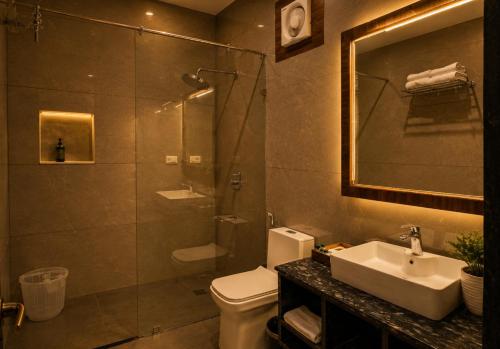 a bathroom with a shower and a toilet and a sink at Jal Dhara Resort in Kumbhalgarh