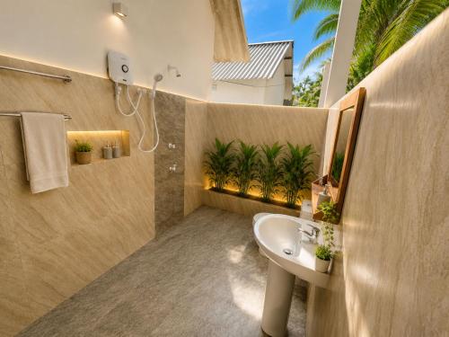a bathroom with a sink and palm trees in it at The Ramp Udawalawe in Udawalawe