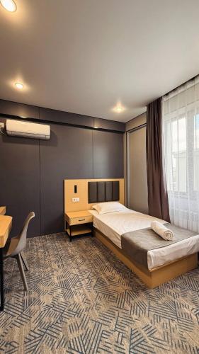 a bedroom with a bed and a table and a desk at Home Inn Hotel in Almaty