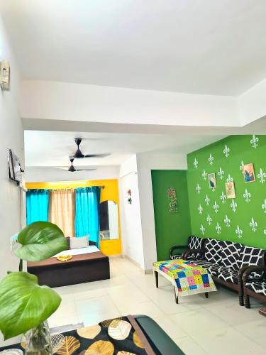 a living room with green walls and a couch at Elite Calangute Beach Holiday Apartments With Pool in Calangute