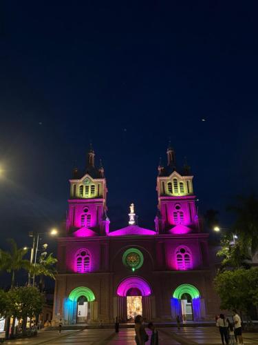a building with pink lights on it at night at Hotel Matias Real in Buga