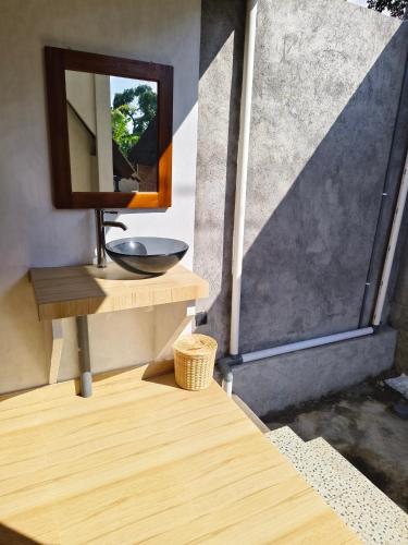 a bathroom with a sink and a mirror at Prima Eco Cabin in Pabean Buleleng