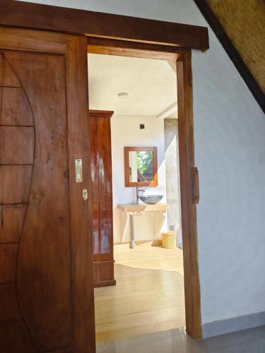 an open door leading to a bathroom in a house at Prima Eco Cabin in Pabean Buleleng
