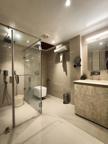 a bathroom with a shower and a toilet and a sink at Club Central in Bolpur