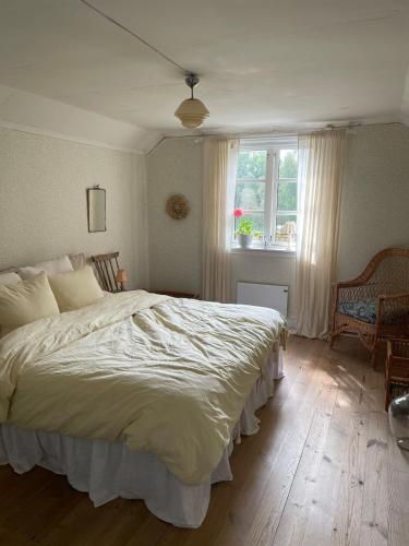 a bedroom with a large bed and a window at Mysigt torp Cozy Cottage in Tranås