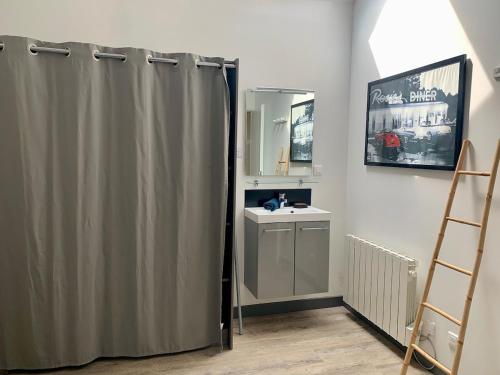 a bathroom with a shower curtain and a sink at Au Ptit MARIUS in Fécamp